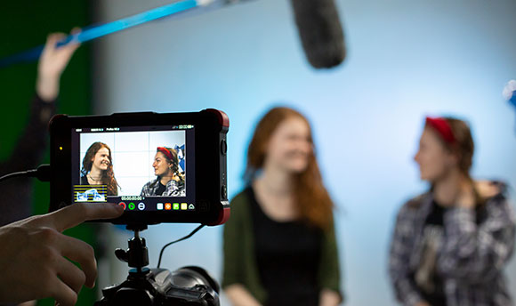 Two  students being filmed in a sound studio
